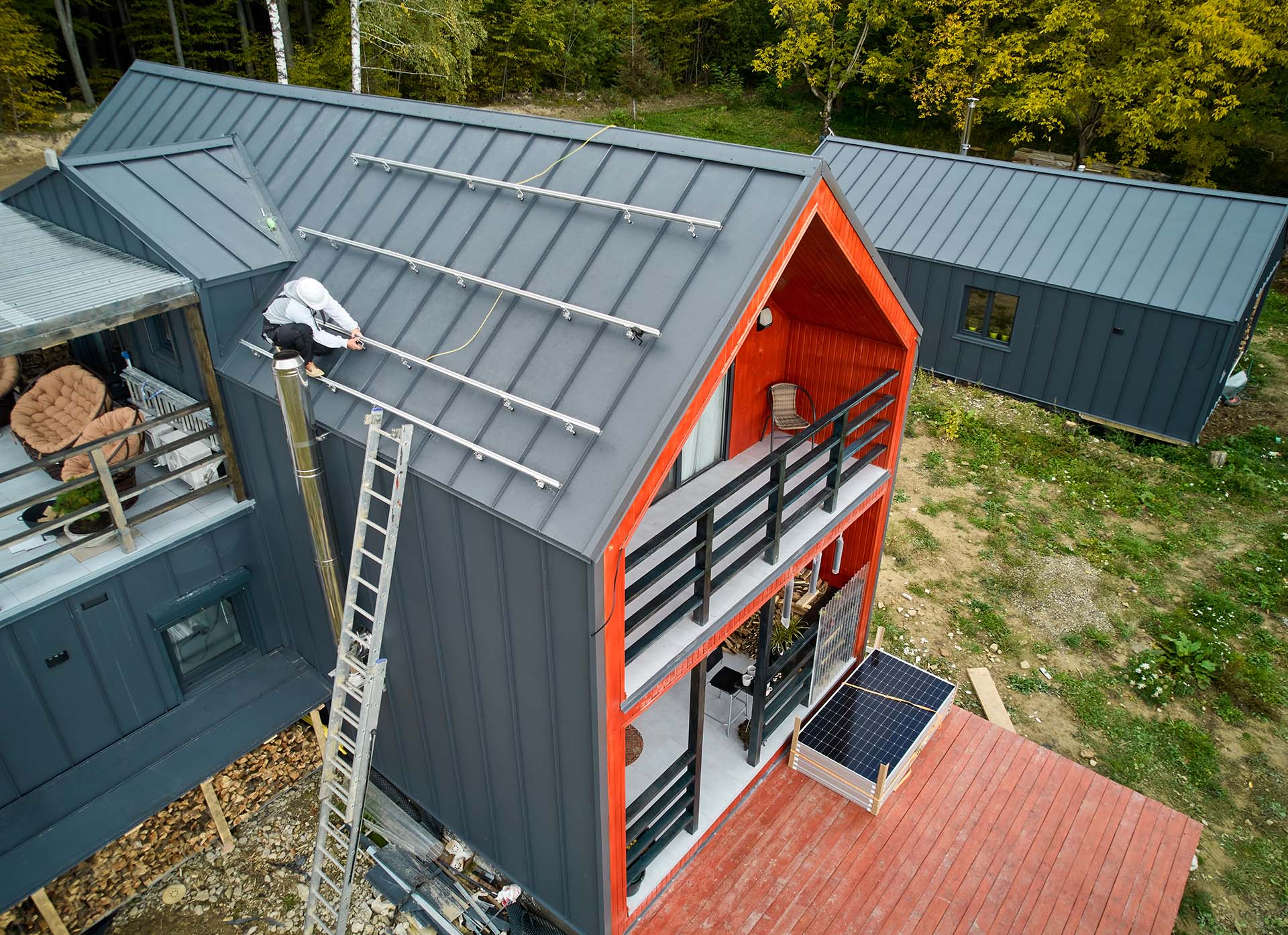 Man worker prepearing for mounting photovoltaic solar modules on roof of house.